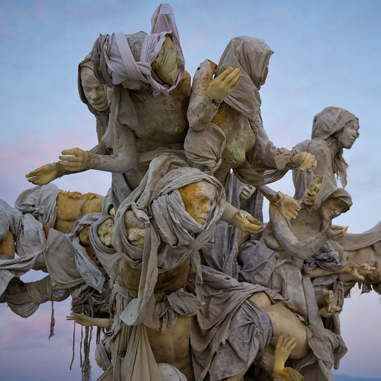 Womantree sculpture, a cluster of shrouded figures rising together against the sky